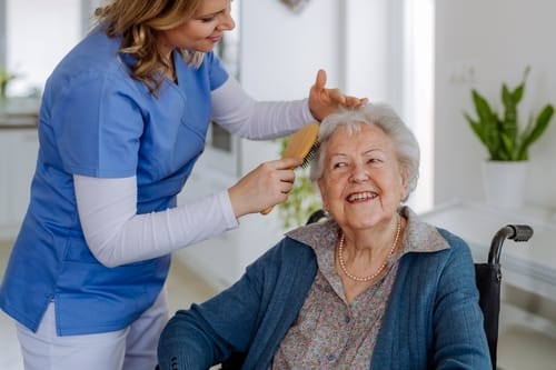 nurse,doing,hairstyle,to,her,senior,woman,client.